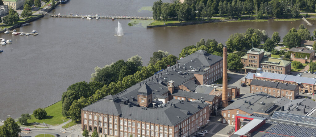 Ilmakuva Kokemäenjoen rannasta, etualalla Porin entinen puuvillatehdas.